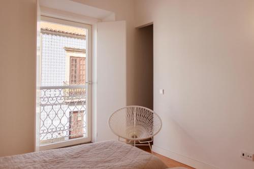 a bedroom with a fan and a window at Casa do Almirante in Tavira
