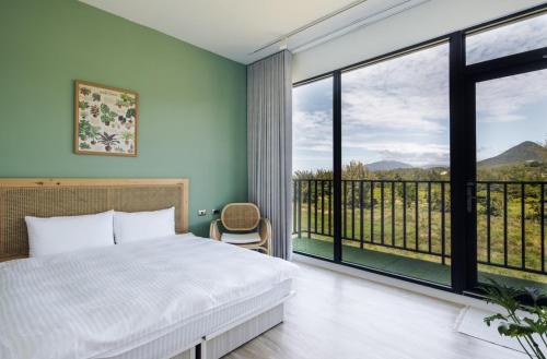 恆春的住宿－墾丁來南島包棟Villa ，一间卧室设有一张床和一个大窗户