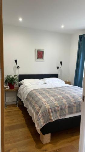 a bedroom with a bed with a plaid blanket at 1 Woodlands in Llandysul