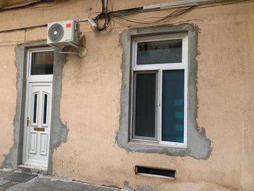 a building with a window and a fan on it at Young Downtown Apartment in Arad