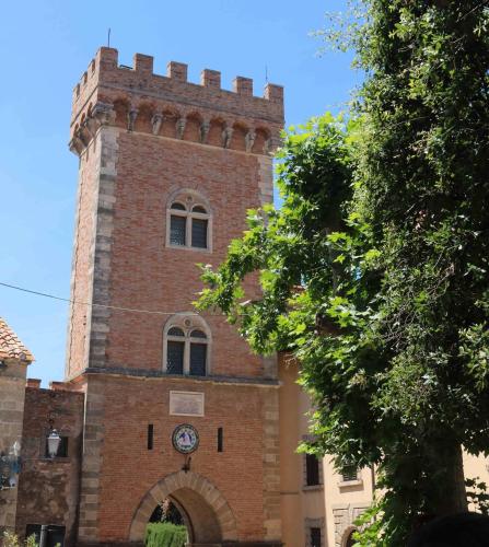 a tall brick building with a clock on it at Ibiscus Beach Village in Follonica
