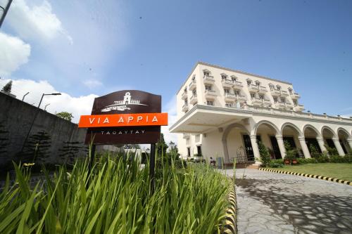 a hotel with a sign in front of a building at Via Appia Tagaytay in Tagaytay