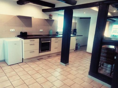 a kitchen with white appliances and a tile floor at Hiller`s Hof in Ilsede