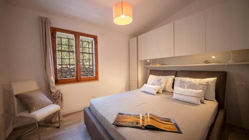 a bedroom with a bed and a chair and a window at Casa Valentina 6 Emma Villas in Porto Istana
