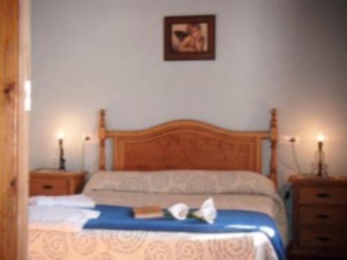 ein Schlafzimmer mit einem Bett mit zwei Schuhen drauf in der Unterkunft House 6 Bedrooms with Pool and WiFi 8798 in Almáchar