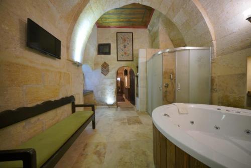 uma casa de banho com uma banheira e um lavatório em Ürgüp Inn Cave Hotel em Ürgüp