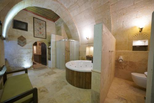 a large bathroom with a tub and a sink at Ürgüp Inn Cave Hotel in Ürgüp