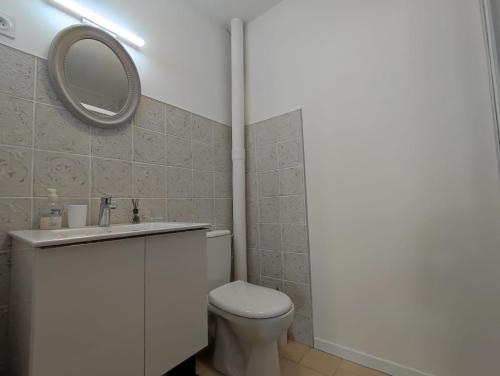 une salle de bain avec des toilettes blanches et un miroir dans l'établissement Appartement avec jardin privatif à 300m de la plage *2*, à Canet