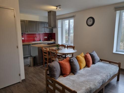 - un canapé avec des oreillers dans la cuisine dans l'établissement Au beau séjour, à Mayet-de-Montagne