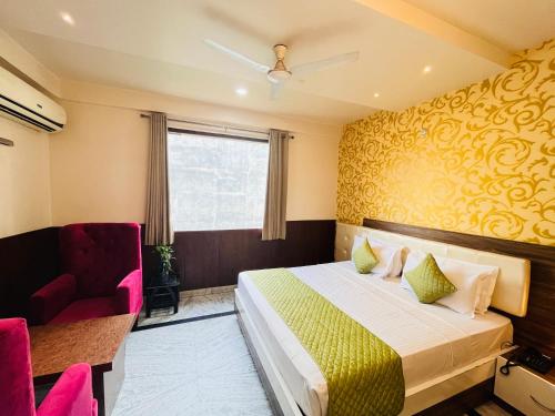 um quarto de hotel com uma cama e uma cadeira em Hotel The Leaf - Gomti Nagar Lucknow em Lucknow