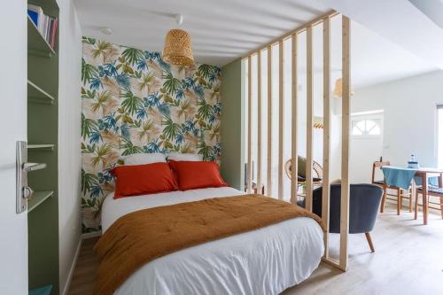 una camera da letto con un grande letto con cuscini rossi di STUDIO COSY NEUF ORSAY - Proche ecoles et entreprises a Orsay