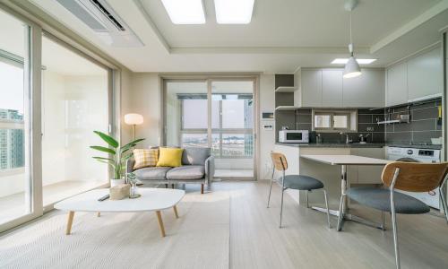 uma sala de estar com um sofá e uma mesa em Urbanstay Songdo Moonlight Park em Incheon