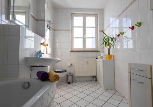La salle de bains blanche est pourvue d'un lavabo et d'une baignoire. dans l'établissement Parkside City Apartments No16, à Leipzig