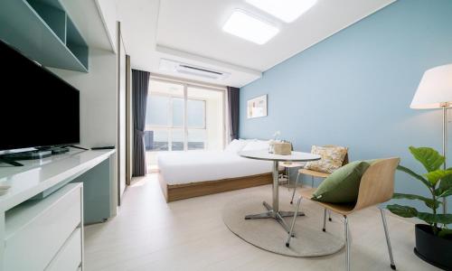 a bedroom with a bed and a table and a tv at Urbanstay Songdo Moonlight Park in Incheon