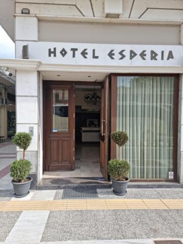 un bâtiment avec une porte en bois et des plantes devant lui dans l'établissement ESPERIA CITY HOTEL DRAMA, à Dráma