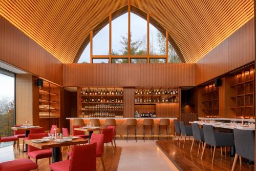 a restaurant with tables and chairs and a large window at Andaru Collection Niseko in Kutchan