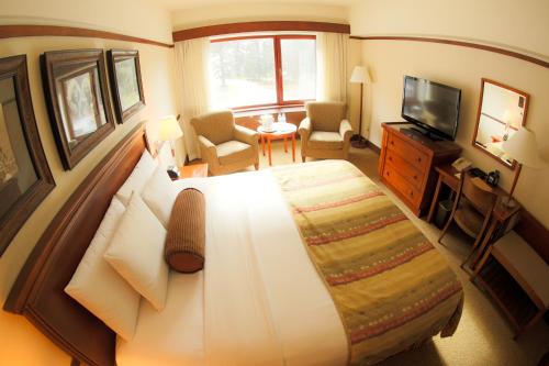 a hotel room with a large bed and a television at Alyeska Resort in Girdwood