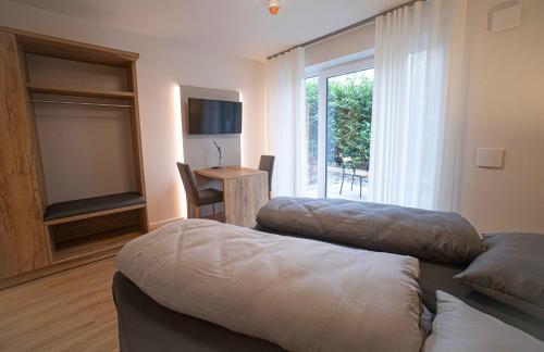 a living room with two beds and a window at Boardinghouse Lingen in Lingen