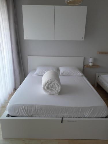 Una cama blanca con una almohada blanca. en Santhooft B , bus 514 Nieuwpoort bad en Nieuwpoort