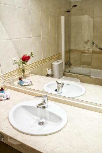 a bathroom with two sinks and a mirror at Hotel Tereñes Costa in Ribadesella