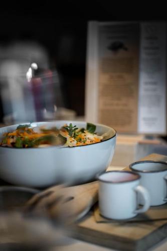 a bowl of soup sitting on a table with cups at Farmhotel Moosmair in Campo Tures