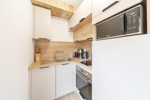 拉維西爾的住宿－Le Pajot - Appt pour 6 proche pistes，厨房配有白色橱柜和微波炉