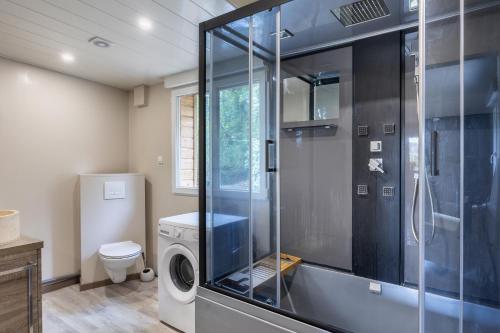une salle de bain avec douche et machine à laver dans l'établissement Natura - En pleine nature proche Disneyland, à Montry