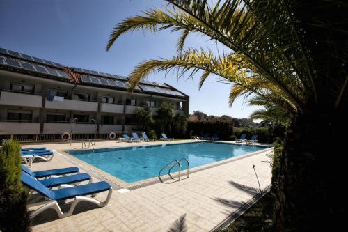 a swimming pool with lounge chairs and a hotel at Hotel Tereñes Costa in Ribadesella