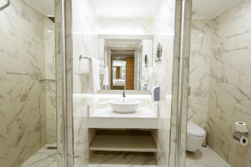 ein Bad mit einem Waschbecken und einem WC in der Unterkunft Calido Maris Hotel Ultra All Inclusive in Kızılot