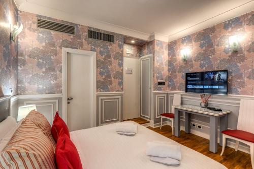 a room with a bed and a desk and a tv at Mangili Garden Hotel in Rome