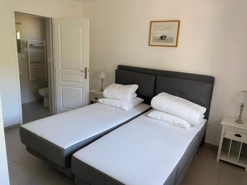 un lit avec deux oreillers dessus dans une chambre dans l'établissement Appartement et Studio Les Glycines, à Clara