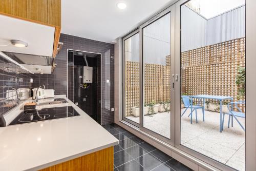 a kitchen with a large window and a table with chairs at Dream On - Clérigos Lofts in Porto