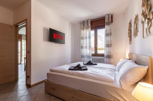 a bedroom with a bed with shoes on it at VIVI TIRANO[300m dal treno rosso del Bernina] in Tirano
