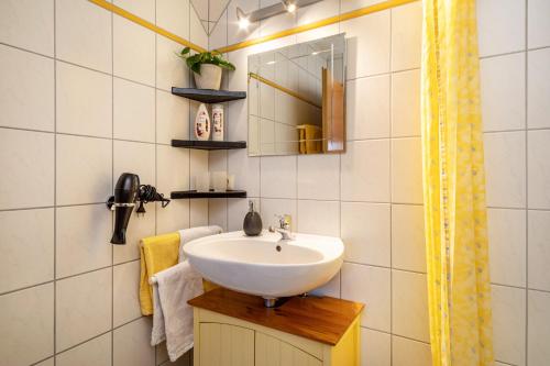a bathroom with a sink and a mirror at Ferienwohnung Hahn in Weißensberg