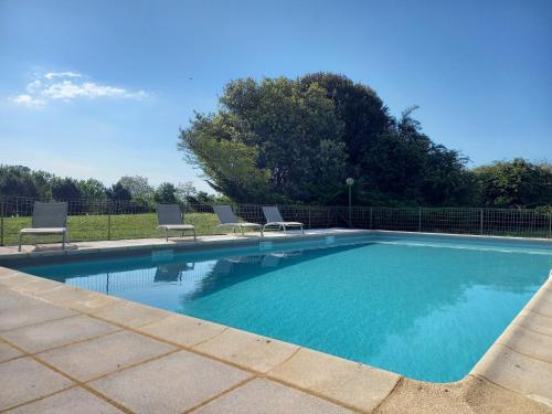 une piscine avec deux chaises et une clôture dans l'établissement Gîte Talia, à Saint-Crépin-et-Carlucet