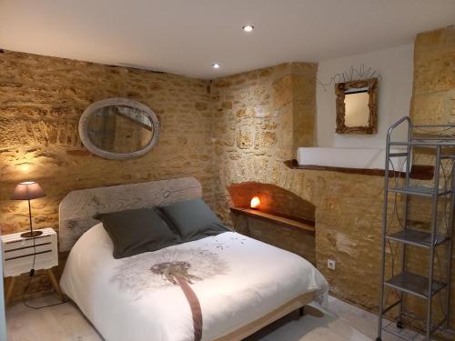 une chambre avec un lit dans un mur de briques dans l'établissement Gîte Talia, à Saint-Crépin-et-Carlucet