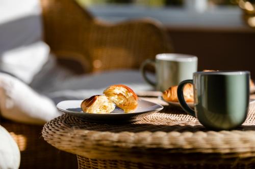 um prato de donuts e uma chávena de café numa mesa em Chichester retreat house with free parking em Chichester