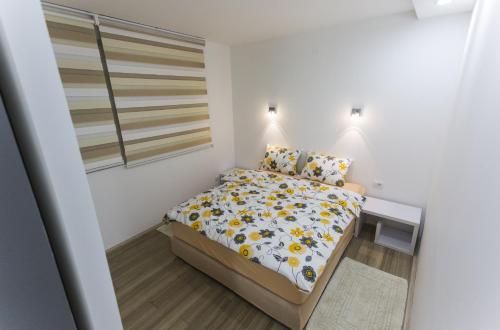 a small bedroom with a bed and a window at Apartment Nevena in Belgrade