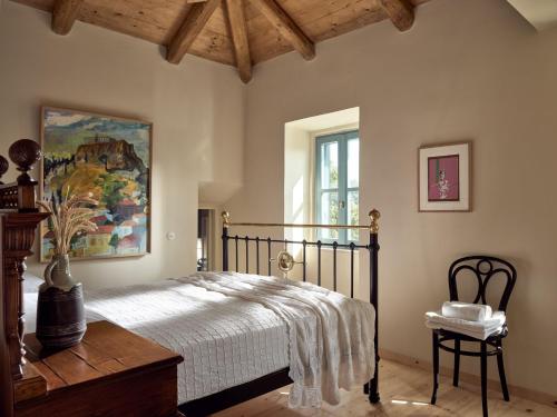 a bedroom with a bed and a painting on the wall at Alkis Farm and Residence in Yírion