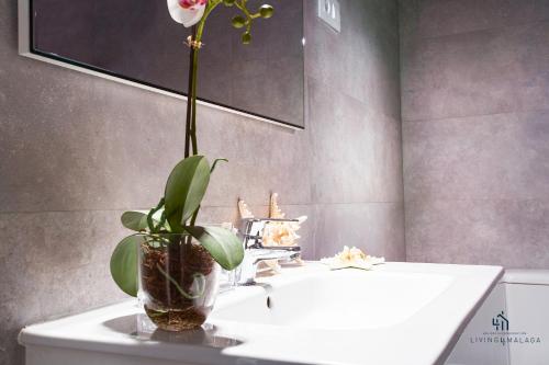 een badkamer met een witte wastafel met een plant erop bij Living4Malaga New Marina Square in Málaga