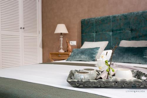 een slaapkamer met een bed en een dienblad met bloemen erop bij Living4Malaga New Marina Square in Málaga