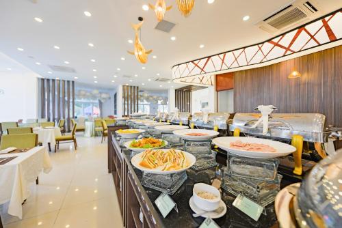 un buffet avec des plats exposés dans un restaurant dans l'établissement Ben Tre Riverside Resort, à Ben Tre