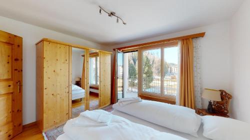 um quarto com 2 camas e uma grande janela em Abitaziun Ova Cotschna 3B - St Moritz em St. Moritz
