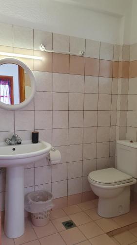 a bathroom with a toilet and a sink and a mirror at Blue Sand in Kalymnos