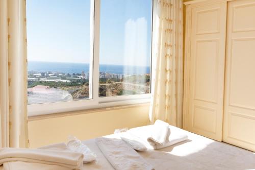 1 dormitorio con ventana y 1 cama con toallas blancas en Gold City Luxury Accommodation, en Kargicak