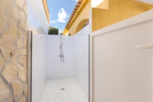 a bathroom with white walls and a stone wall at Villa Sueño in Mazarrón