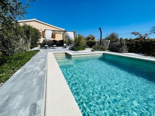 ein Swimmingpool mit blauem Wasser in einem Hof in der Unterkunft Holiday House Tesser with Pool in Galižana
