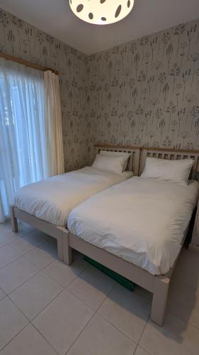 two twin beds in a bedroom with a wall at Stylish Garden Apartment at Paphos Harbour in Paphos City