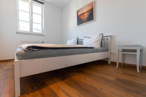 uma cama branca num quarto com uma mesa em Parkside City Apartments No15 em Leipzig