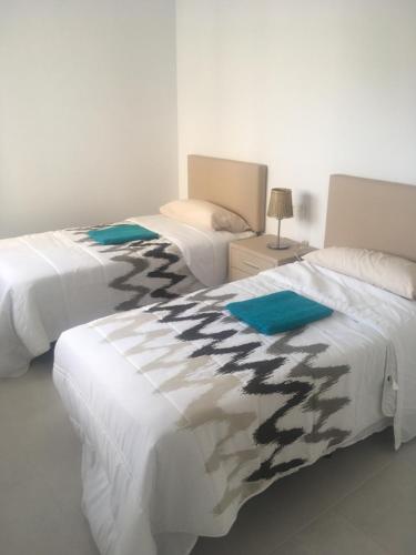 two beds sitting next to each other in a bedroom at Casa Escocesa in San Pedro del Pinatar